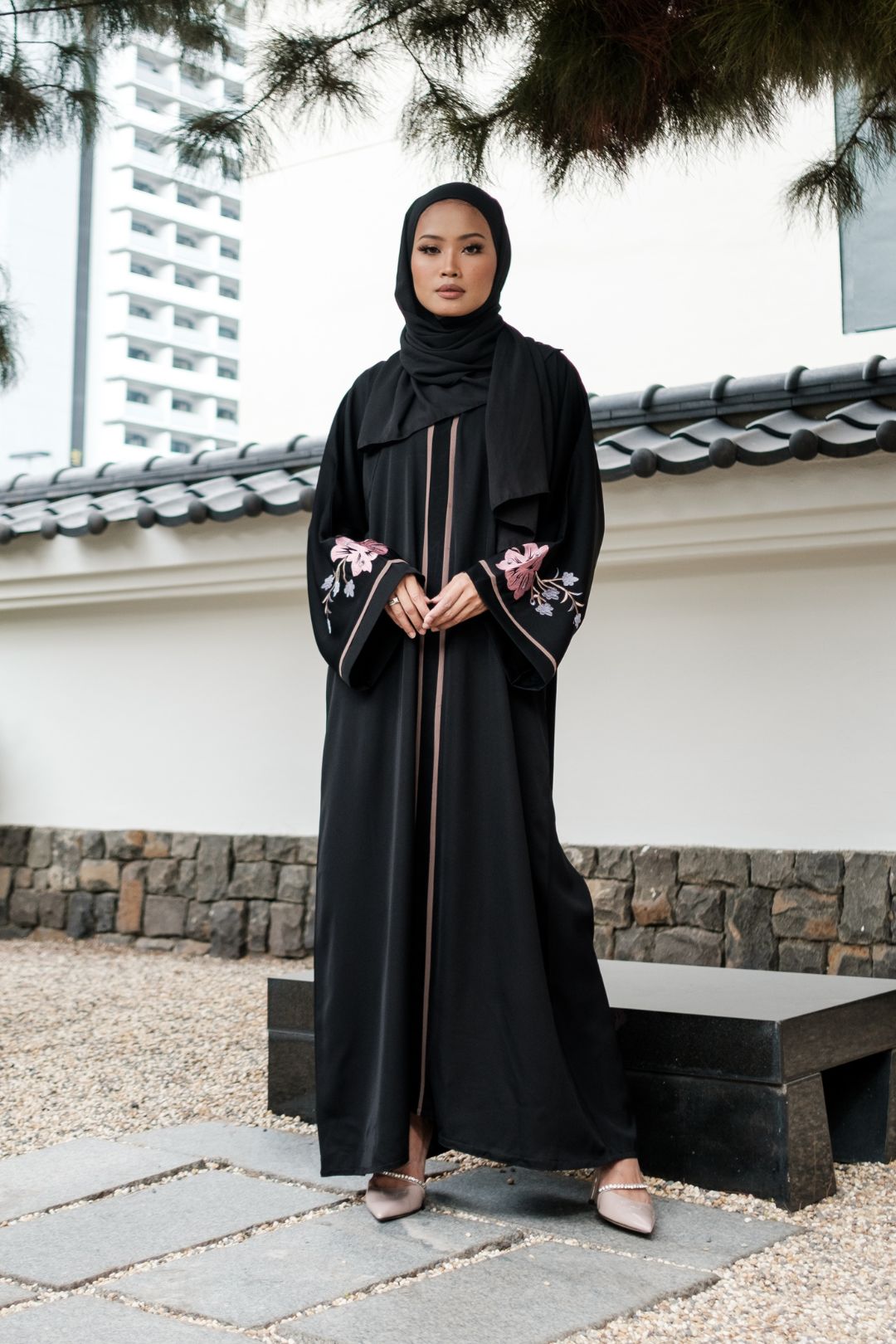 Singapore Muslimah model in hijab wearing black nidha closed abaya with pink and blue floral embroidery. 